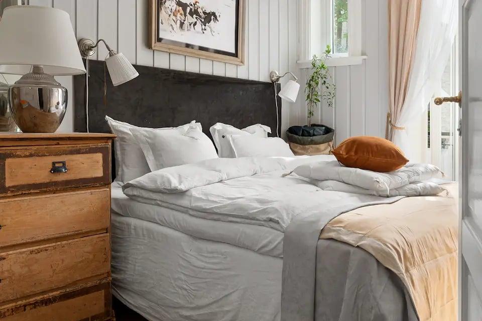 Chambre au mobilier en bois et linge blanc
