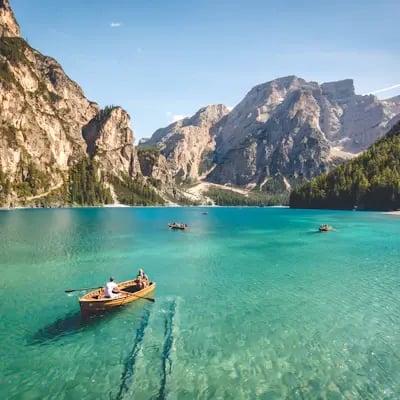 Barque sur un lac turquoise entouré de montagnes