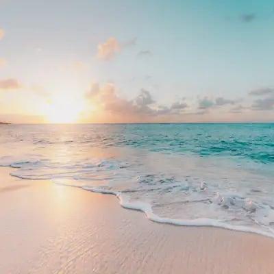 Vague sur une plage au coucher du soleil