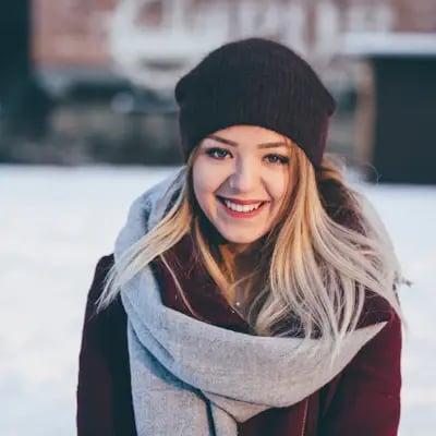 Portrait d'une femme souriante en bonnet et écharpe